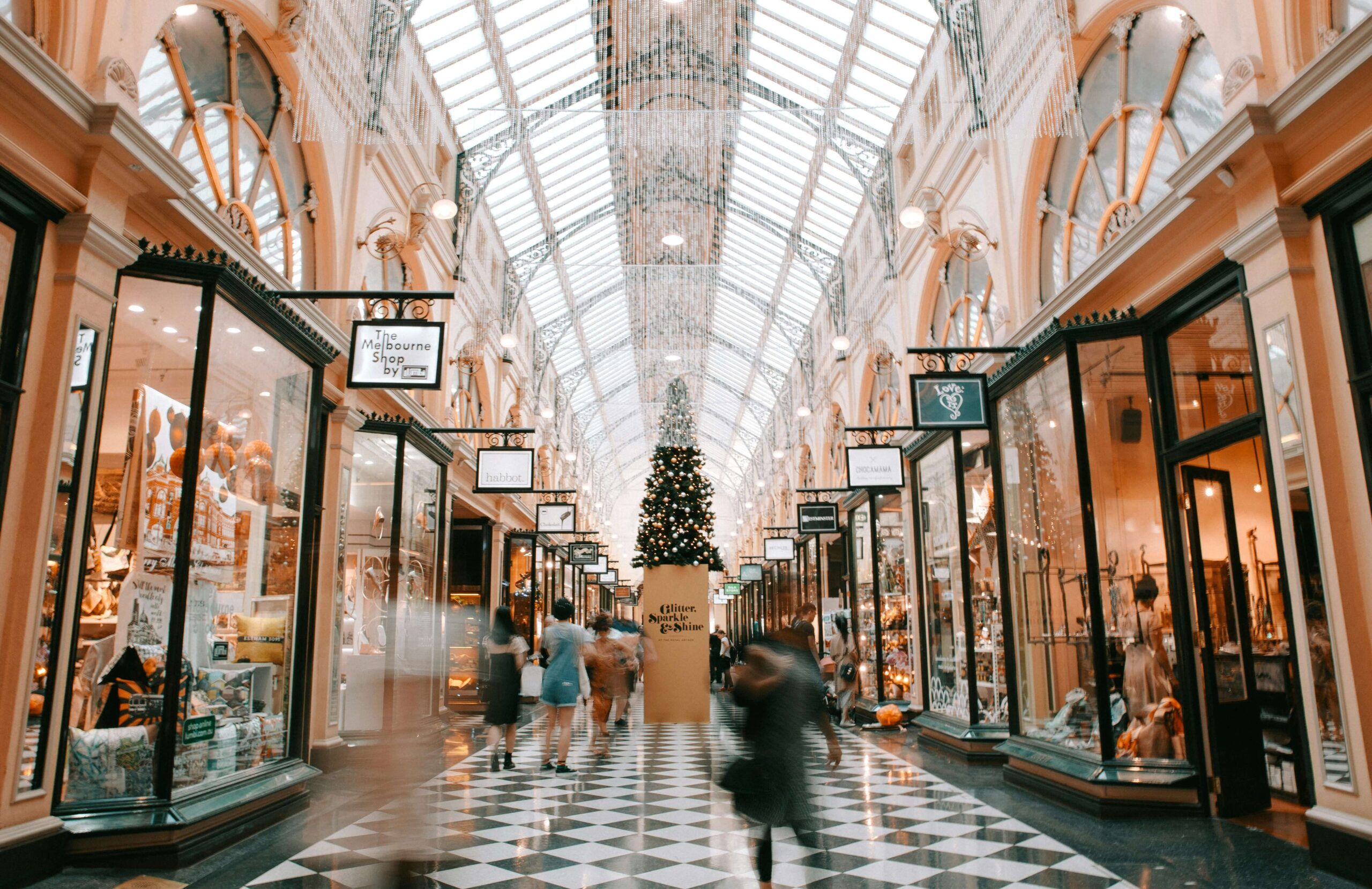 ustling indoor shopping arcade with a glass ceiling and holiday decorations, highlighting a busy retail atmosphere in the holidays season